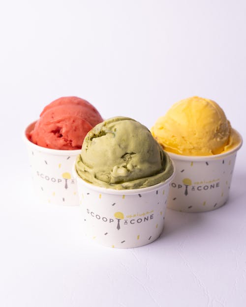 Three different flavors of ice cream in small cups