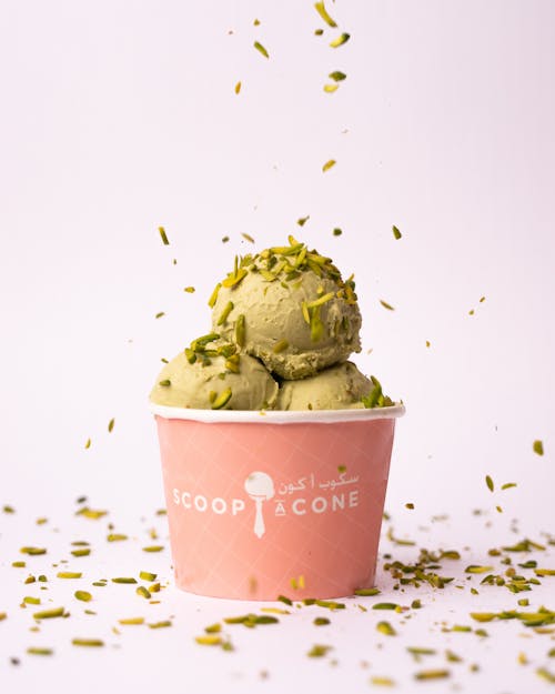 A scoop of ice cream with pistachio and a green leaf