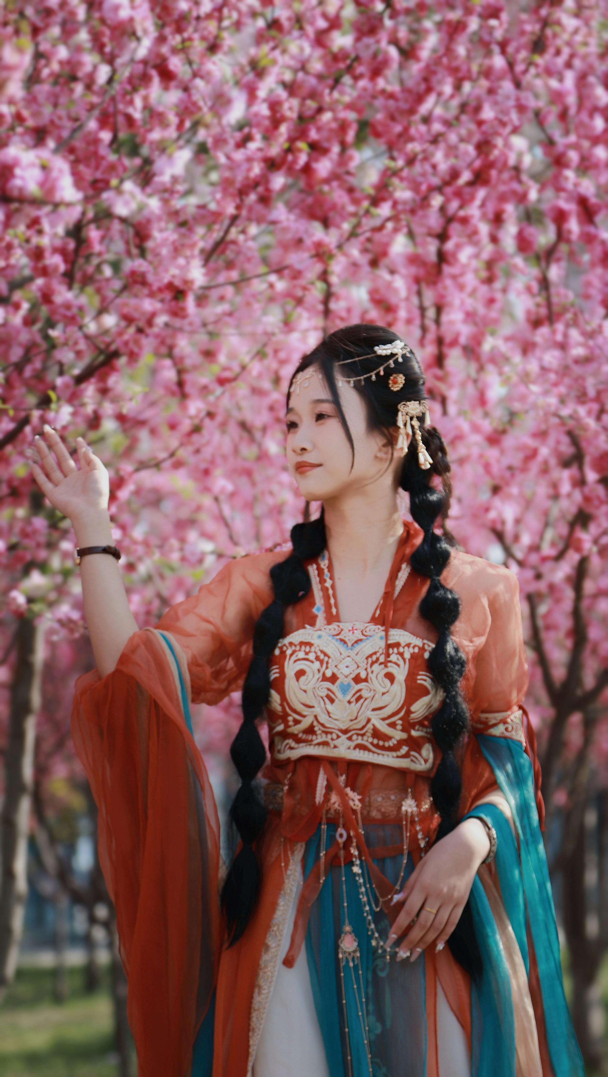 woman in hanfu dress standing under spring tree