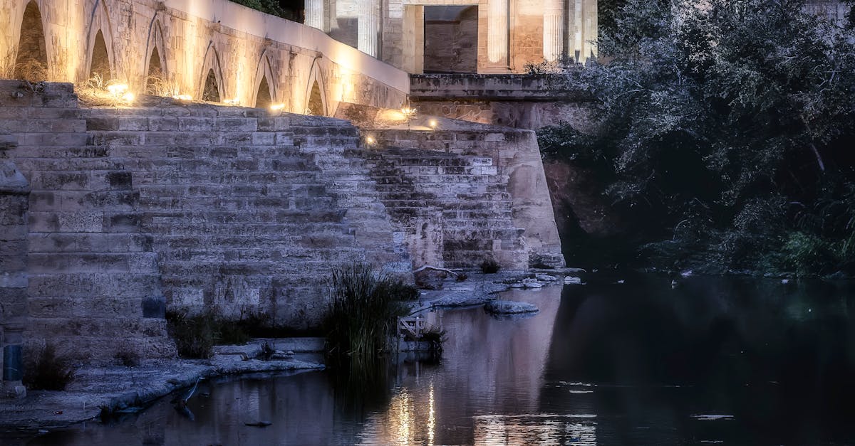 Scenic view of Córdoba's Roman Bridge illuminated at night with reflections in the river.