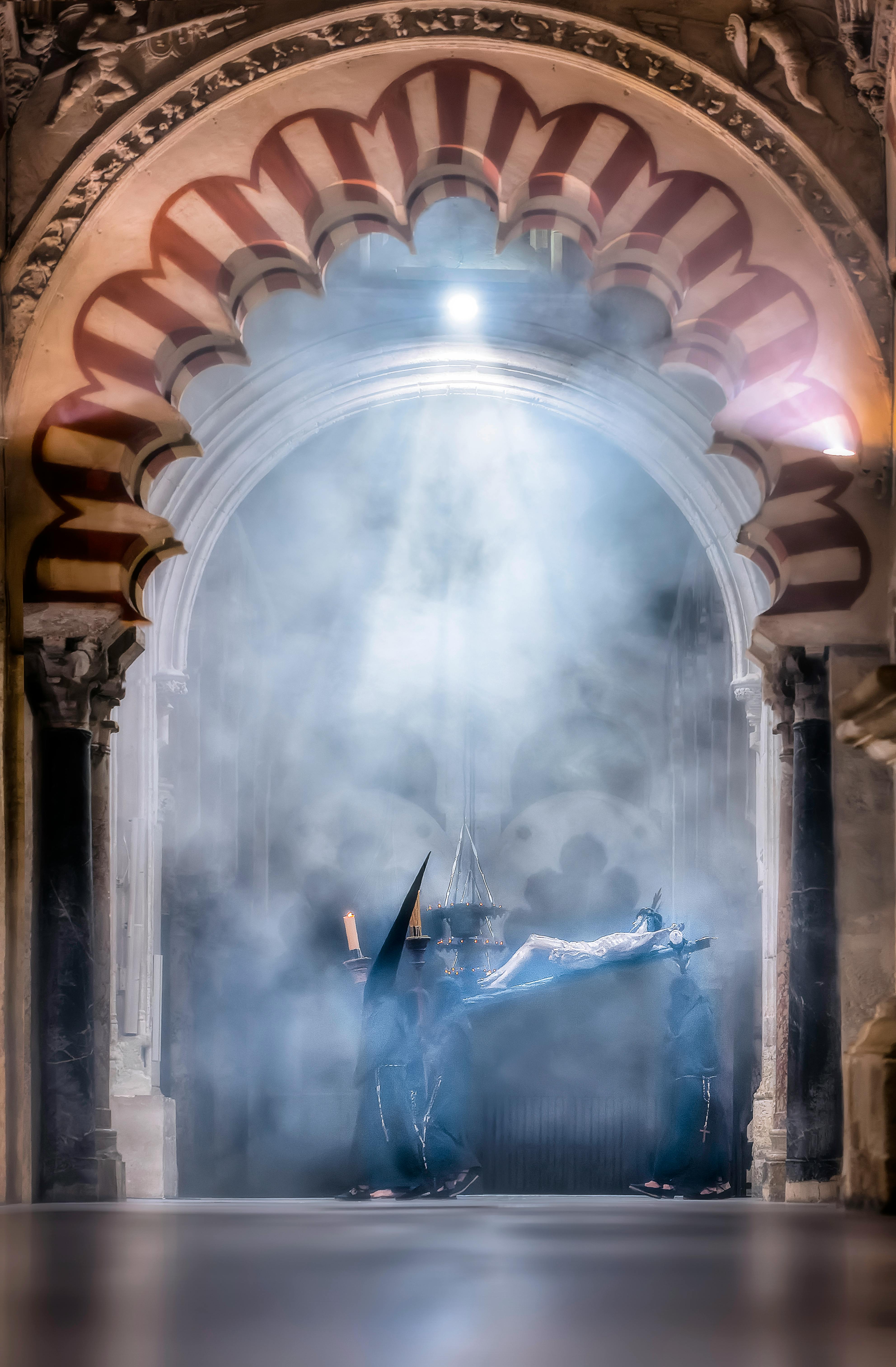 Atmospheric scene of a religious procession with capirotes in Córdoba's Mezquita, shrouded in mystery.