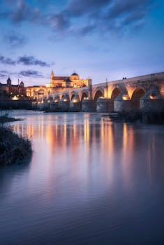 Captivating twilight scene of the Roman Bridge and Guadalquivir River in Córdoba.