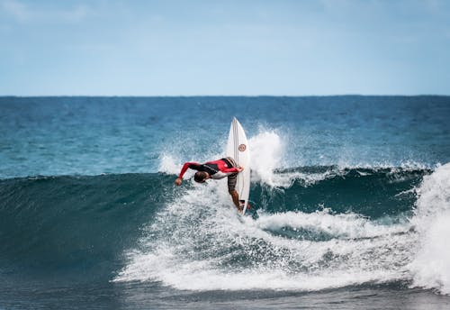 Pessoa Usando Roupa De Mergulho Vermelha E Preta Surfando Nas Ondas