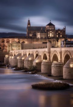 Elegant view of the Roman Bridge in Córdoba at twilight, highlighting Gothic and Islamic architecture.