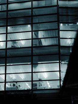 Illuminated office building with a modern glass facade at night.