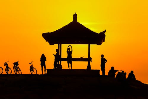Silhouette of People Standing Near Gazebo