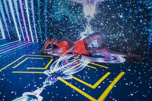 A woman laying on the floor in front of a starry background