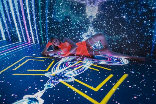 Vibrant display of a woman in a neon-lit art installation, showcasing immersive digital art.