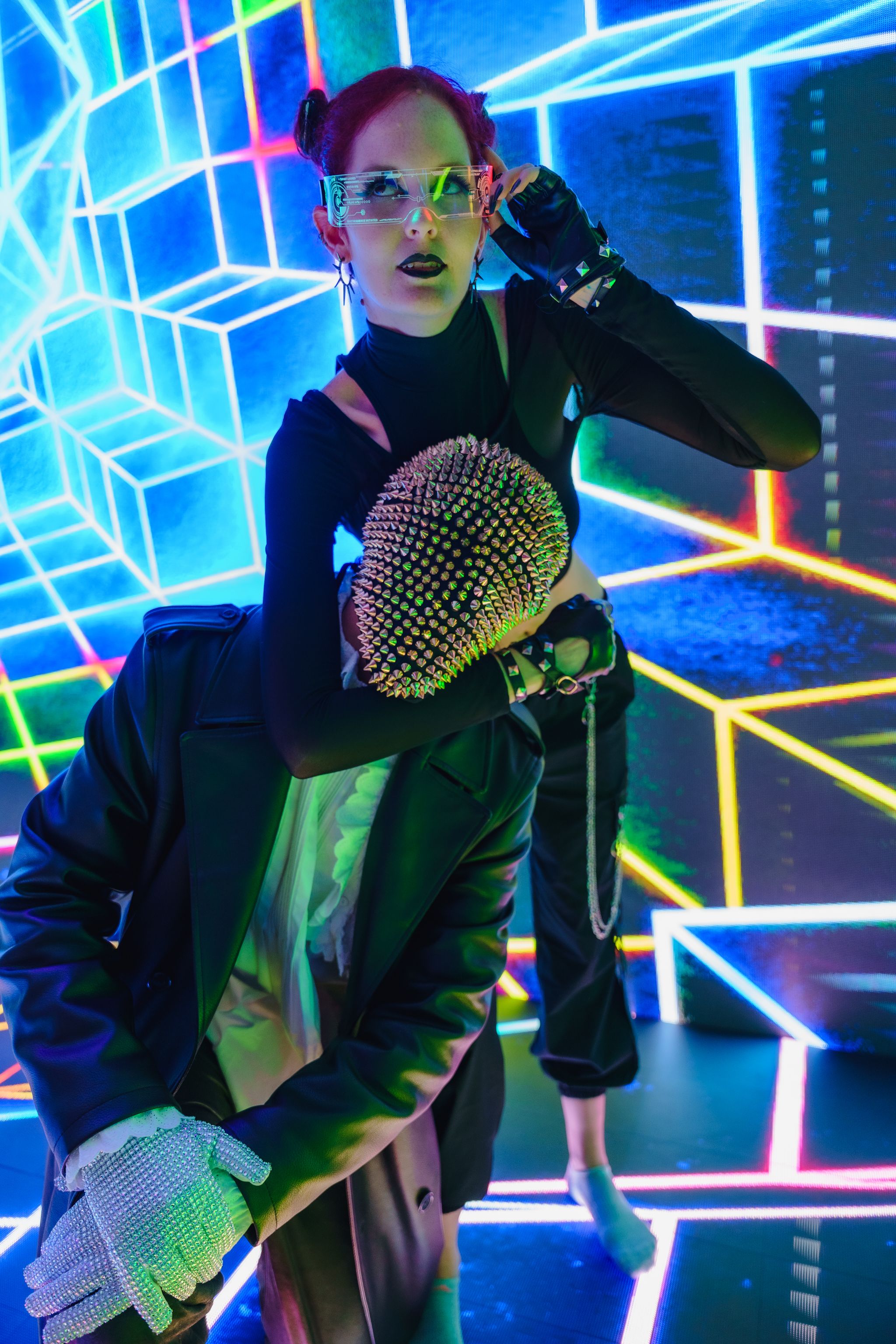 Dynamic duo perform in neon-lit club with futuristic style.