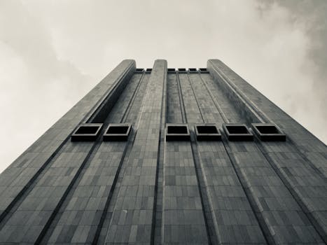 A towering brutalist skyscraper in NYC, captured from below with striking geometry and no windows.