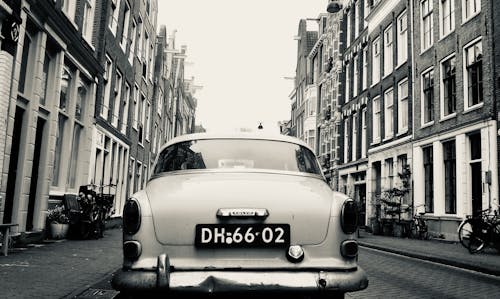 A vintage car is parked on a street in amsterdam
