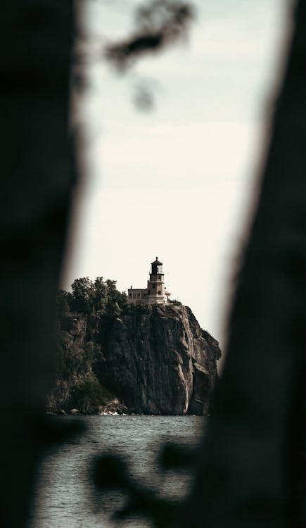 Free A lighthouse is seen through trees in the distance Stock Photo