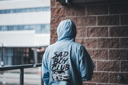 A person wearing a hoodie that says sad boy club