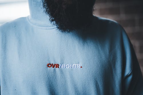 A man with a beard and a hoodie that says over night