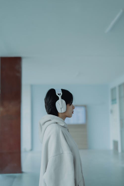 A woman wearing headphones in an empty room