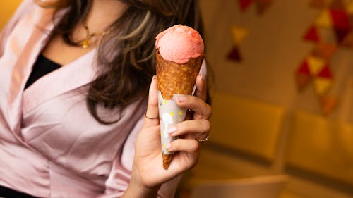 A woman holding an ice cream cone in her hand