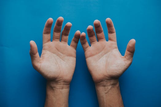 Two open hands against a solid blue background, symbolizing openness and communication.