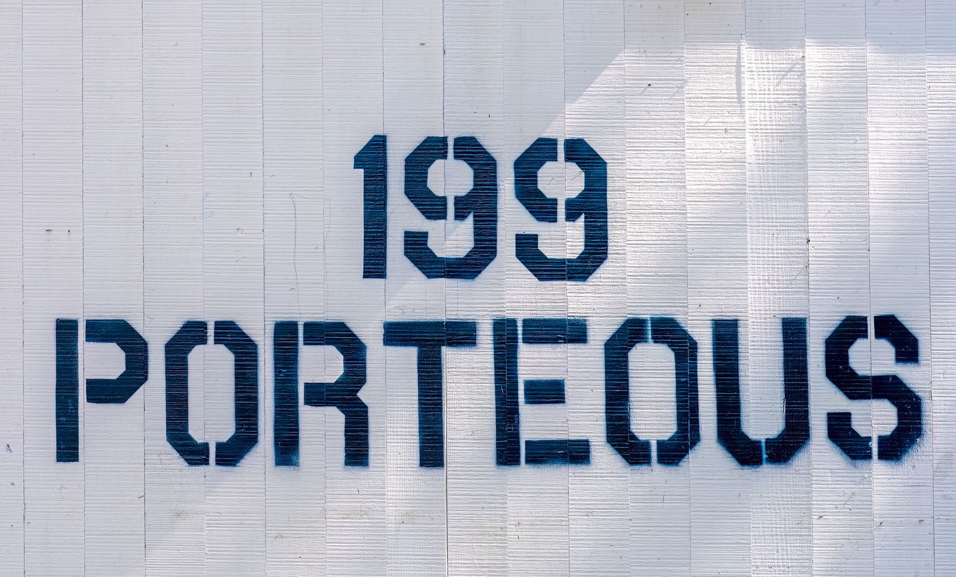 Close-up of wall sign with the numbers 199 and text Porteous in bold font on a white background.