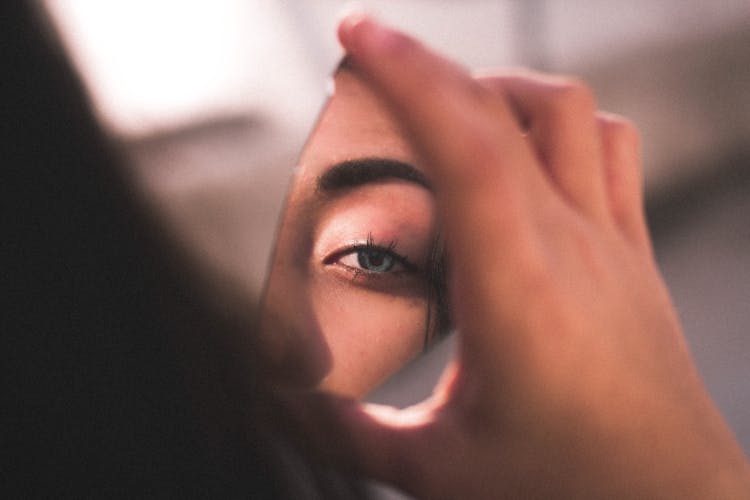 Reflection Of Woman's Eye On Broken Mirror