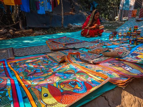 Free Colorful traditional Indian crafts on display with a woman in vibrant attire. Stock Photo