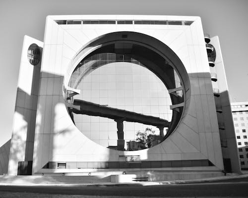 A black and white photo of a building with a circular window