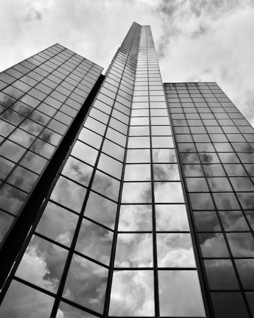 Black and white photo of tall buildings with clouds