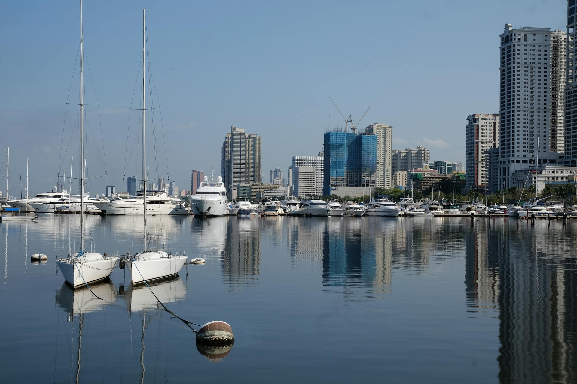 Explore the vibrant waterfront of Pasay in the Philippines with towering skyscrapers and luxury yachts.