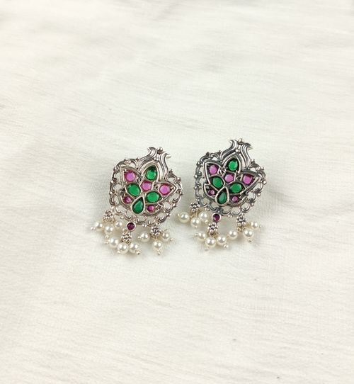 Free Close-up of elegant silver earrings with pearls and colorful gems on a white background. Stock Photo