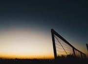 宁静的日落场景在户外拍摄，天空晴朗，映衬着栅栏的轮廓