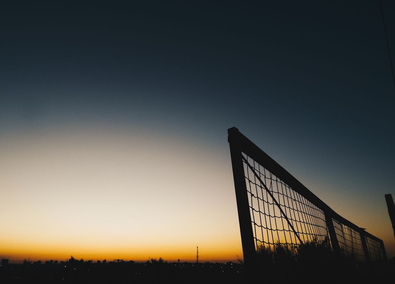 peaceful sunset scene with fence silhouette and clear sky captured out