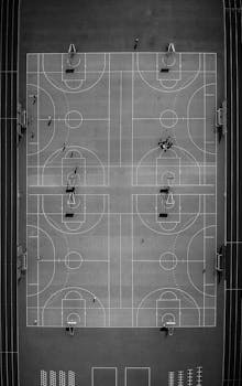Drone captures a striking black and white aerial view of a basketball court in Chamonix, France, highlighting its symmetry.