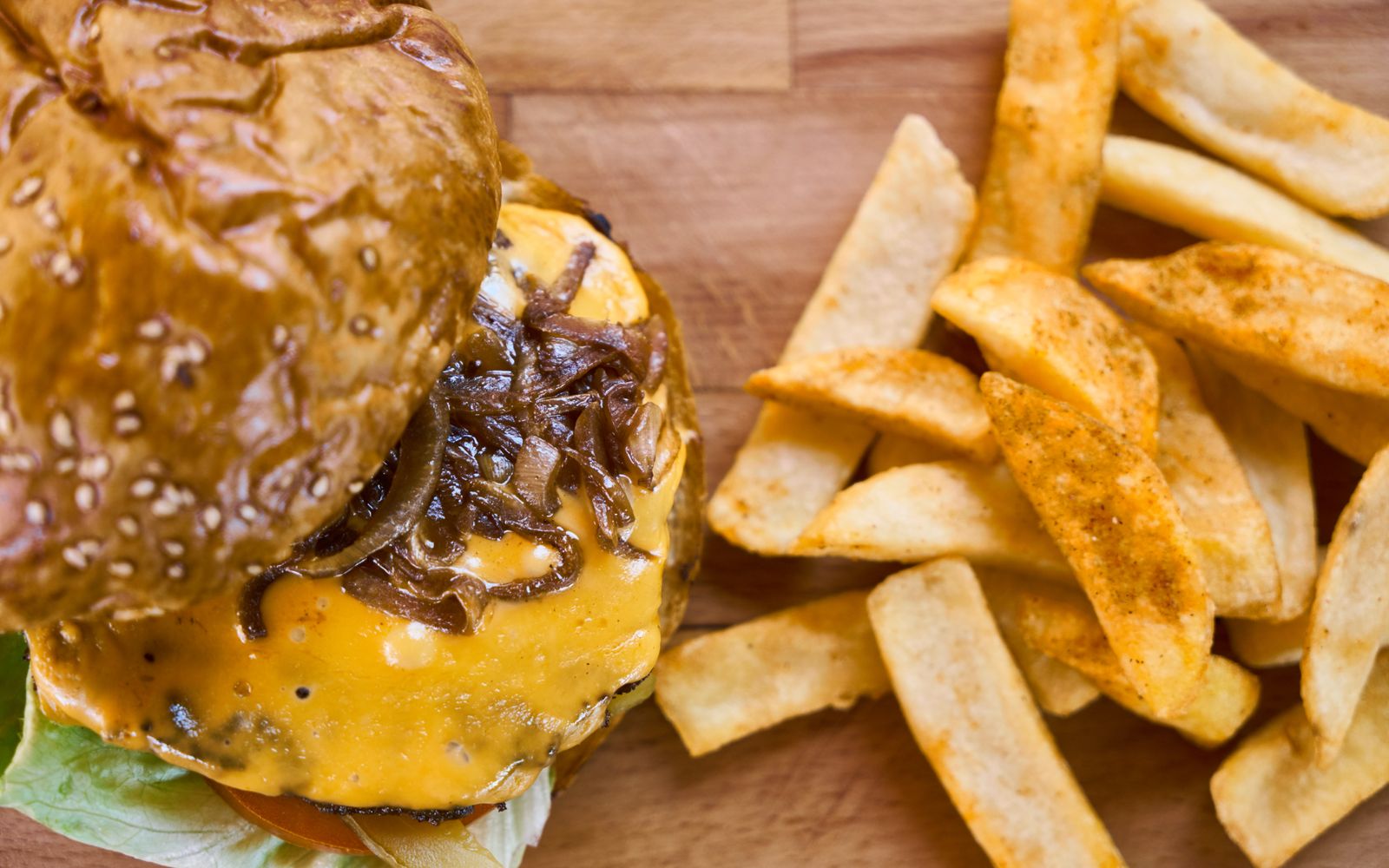 Foto de Hambúrguer caseiro com cebola caramelizada e batatas rústicas