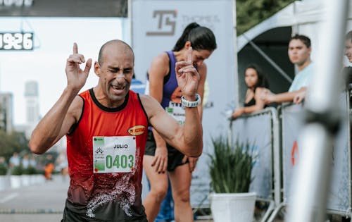 Man in Red Tank Top Winning A Marathon