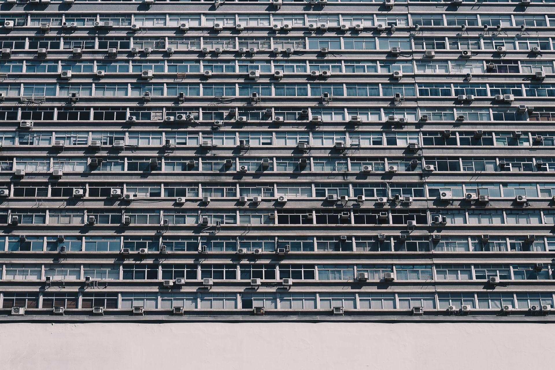 Contemporary building facade in São Paulo, Brazil, showcasing modern architectural design with glass windows and air conditioners.