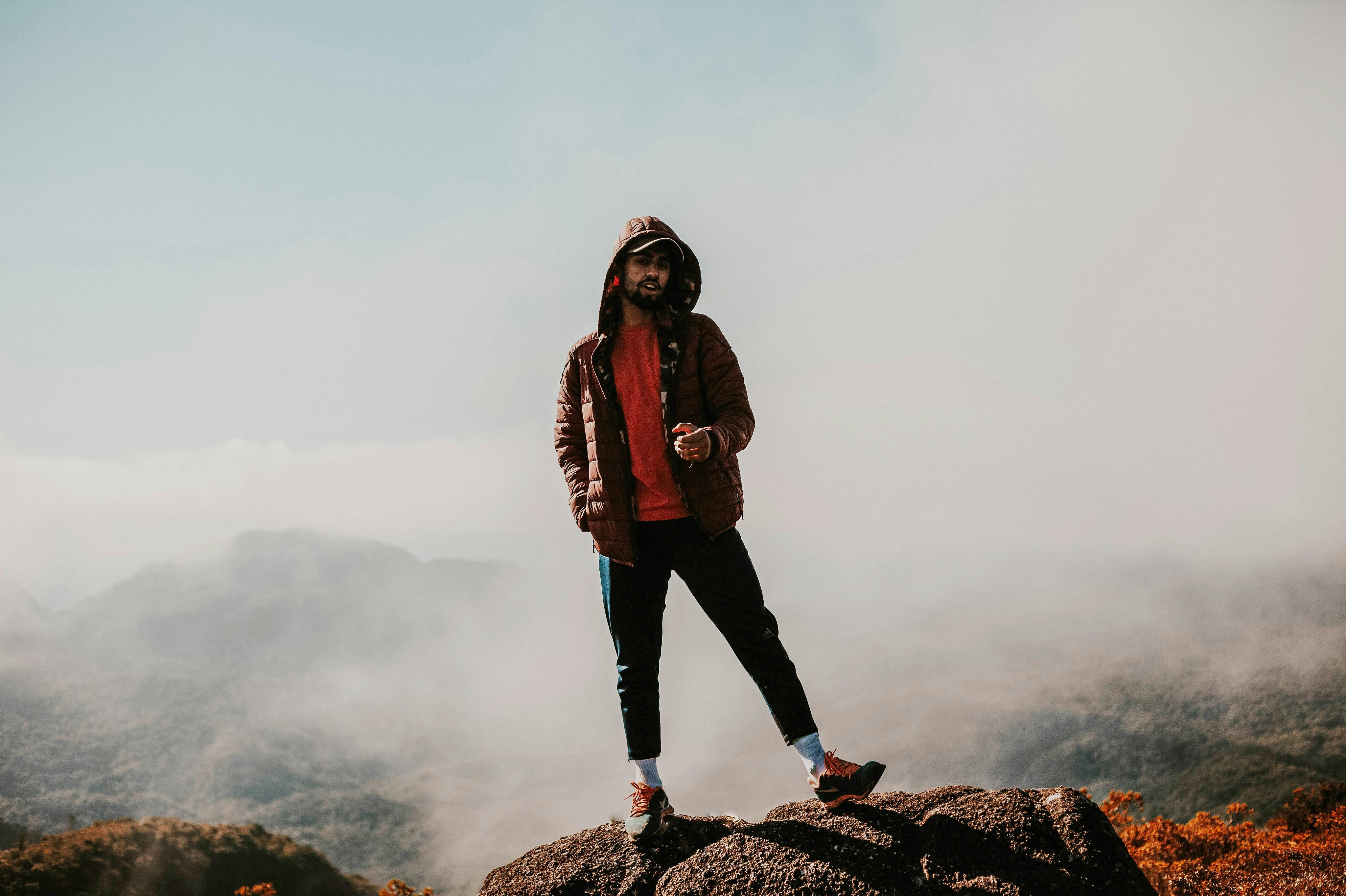 在巴西贝洛阿尔托，一个人站在薄雾笼罩的山顶上，展示着户外冒险