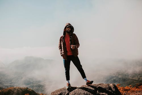 Man Standing on Top of Rock