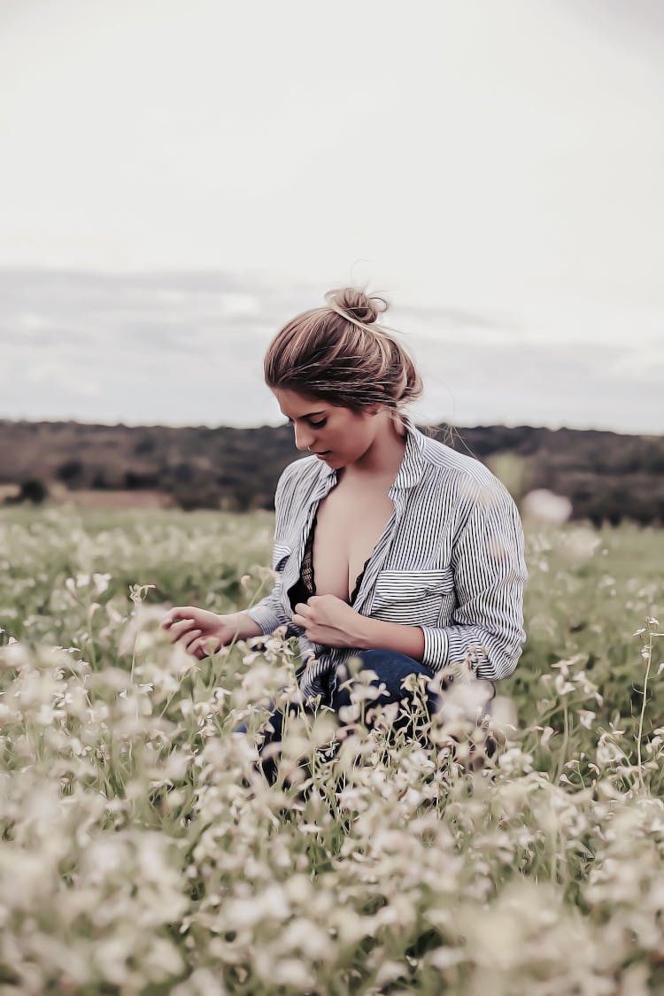 Photo Of Woman With Opened Cleavage Knelling In The Middle Of Grass Field