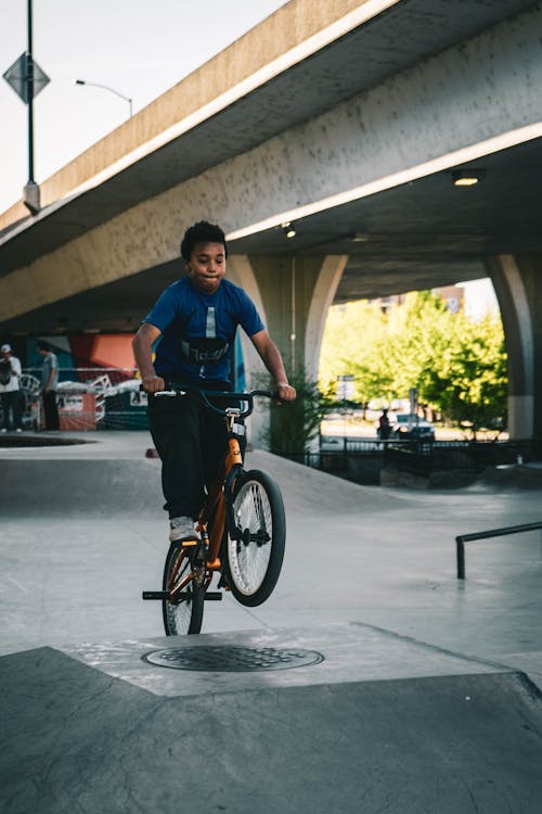 ランプで自転車に乗る青いシャツの少年