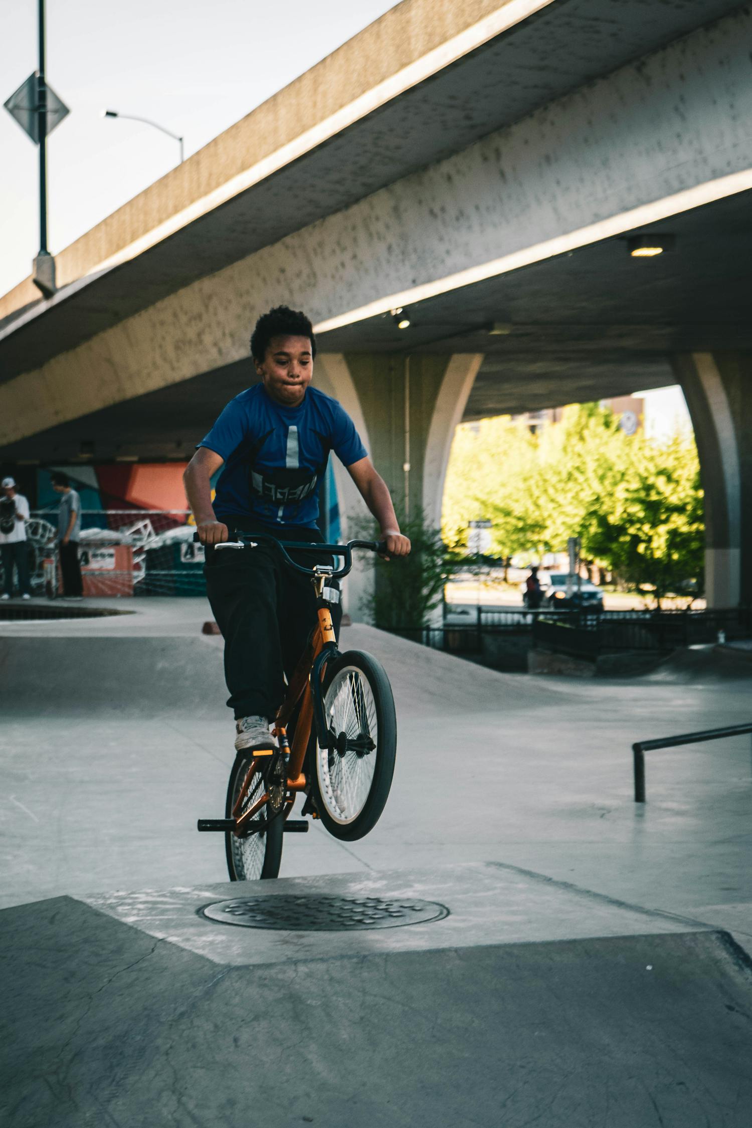 Boy in Blue Shirt Riding Bike on Ramp