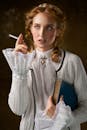 一位穿着复古蕾丝服装的女人，手里拿着一本书，正抽着烟