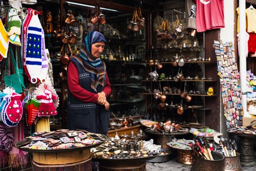 Free Elderly woman in hijab selling goods at a traditional Turkish bazaar. Stock Photo