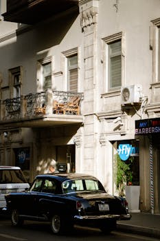 Classic vintage car parked on a sunlit street in Baku, Azerbaijan.