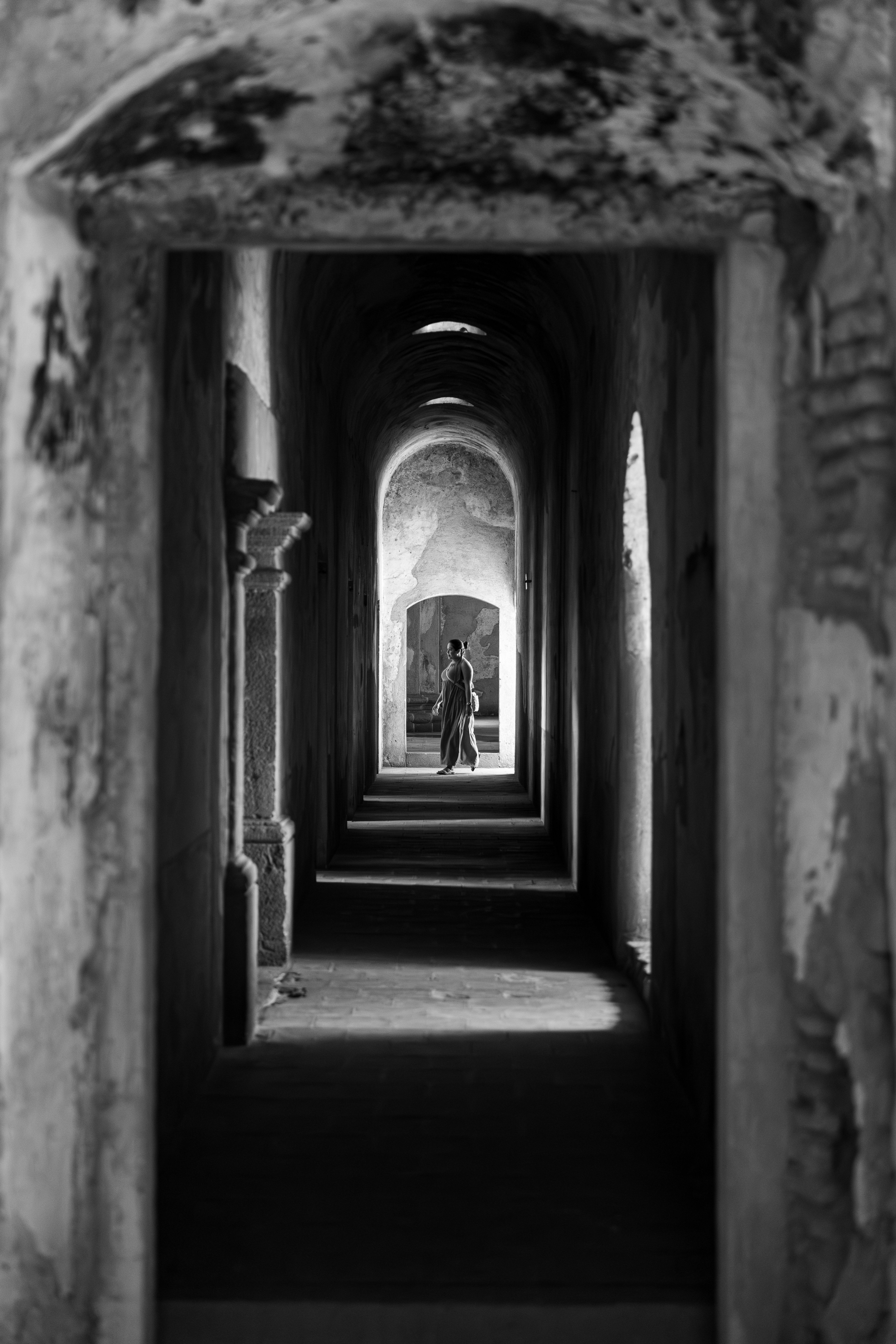 A woman walking through a mysterious and narrow corridor in Antigua Guatemala.
