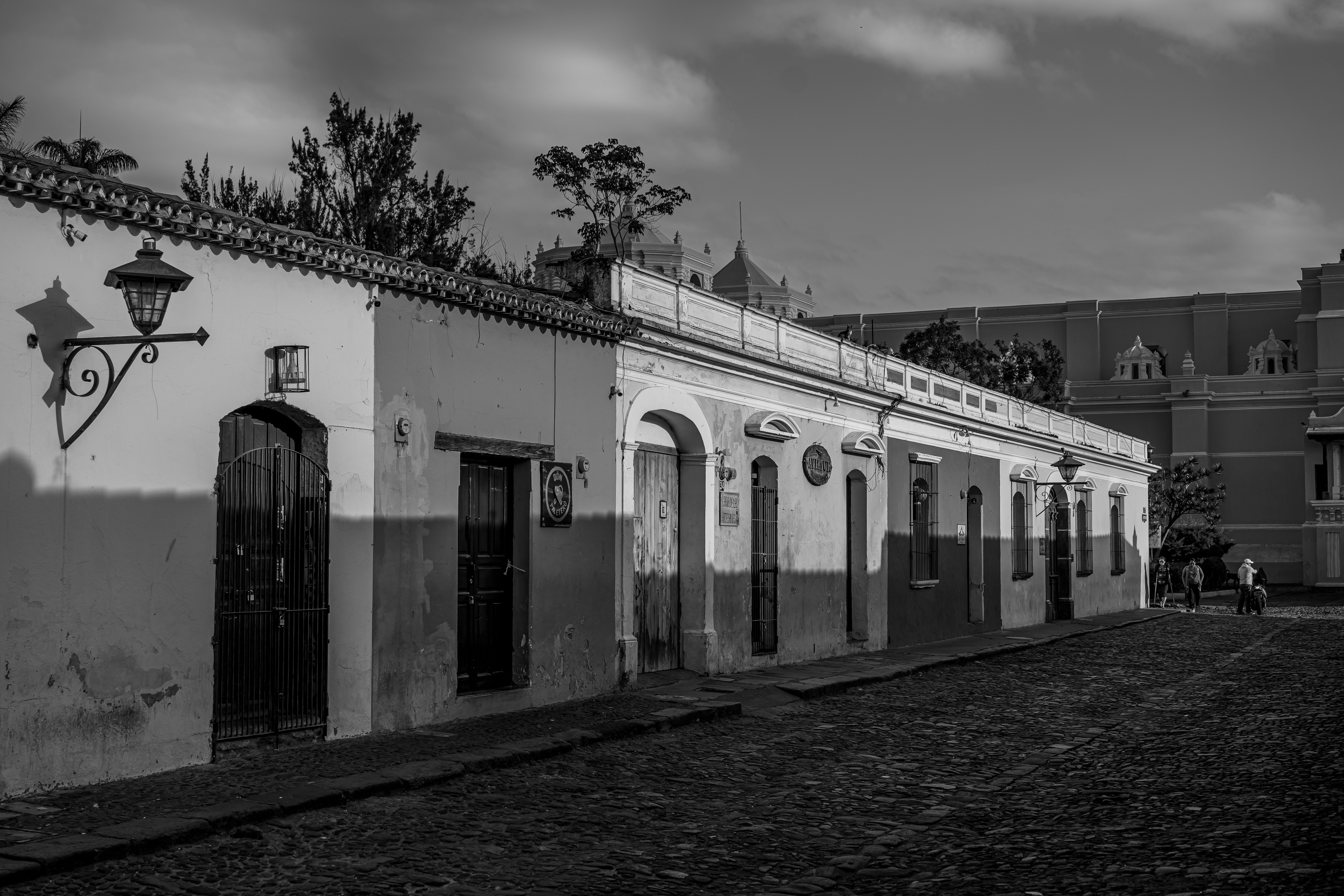 Charming black and white image of Antigua Guatemala's cobblestone streets and colonial architecture.