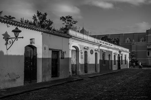 Charming black and white image of Antigua Guatemala's cobblestone streets and colonial architecture.