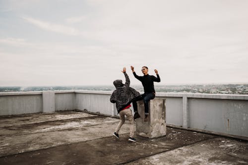 Free Two Men Going to High Five on Top of Building Stock Photo