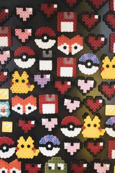 A vibrant display of bead art showcasing popular symbols like pixelated hearts and gaming icons.