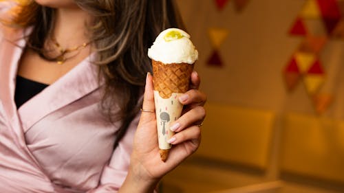 A woman holding up an ice cream cone