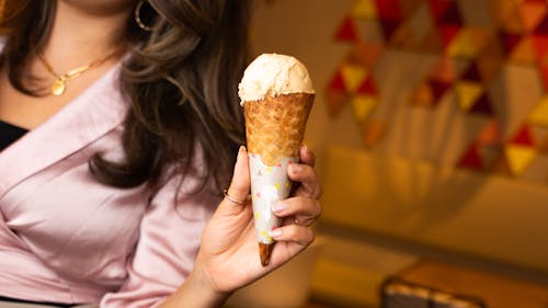 A woman holding an ice cream cone in her hand