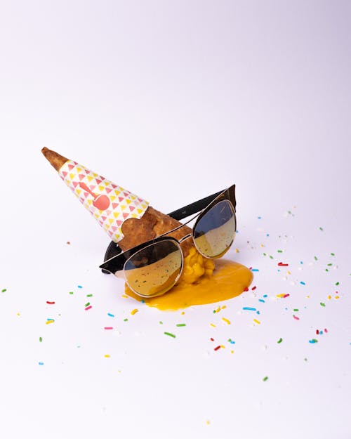 A cone with sunglasses and sprinkles on it